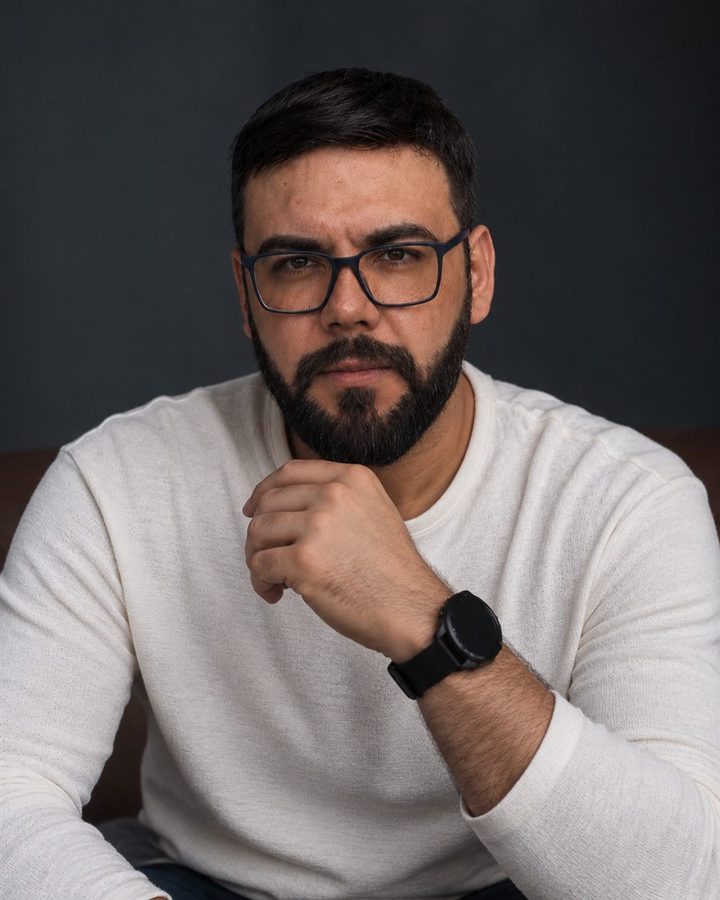Rodney Ferreira, de óculos e blusa clara, com a mão no queixo